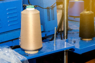 Spools with colored threads on a machine for knitting socks