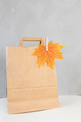 Colorful autumn leaves in a brown craft bag. Sale and shopping concept.