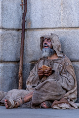 Ragged beggar begging on the street