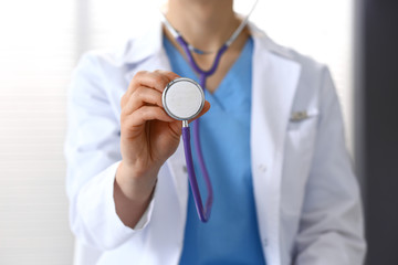 Doctor holds stethoscope head, closeup. Physician ready to examine and help patient. Medical help and insurance in health care, best treatment and medicine concept