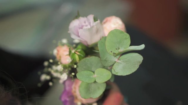 Girl is holding a colored buttonhole in her hands close up
