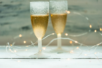 two glasses of champagne on background of lights