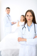 Medicine doctor standing and  smiling on the background with patient in the bed