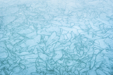 Abstract blue background made of frozen ice crystals on a pond.