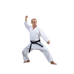 On a white background, an active athlete does formal karate exercises.