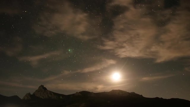Full moon trace above the mountains at night Sky dome with stars as background Time lapse video