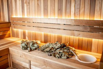Bath brooms with towels on the bench at the russian traditional sauna