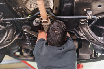 Mechanic repairing exhaust system
