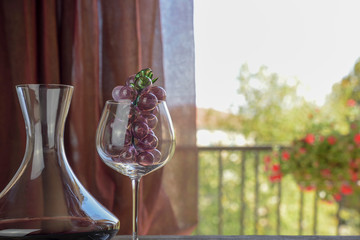 Italian red wine inside the decanter and goblet with decorations. Natural background