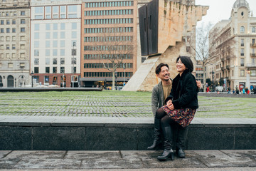 Asian happy tourist couple sitting on the lap