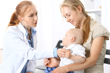 Doctor examining a little boy with stethoscope. Mother holds her son on her lap. Motherless and medicine concept