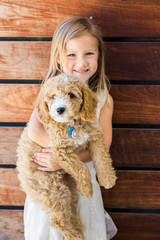 Little Girl Holding Golden Doodle Puppy