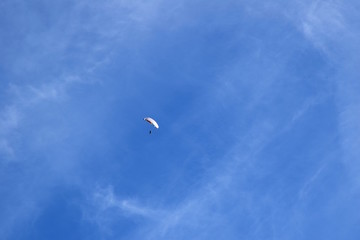 Fototapeta na wymiar Paragleiter segelt alleine und hoch oben durch die Luft