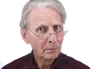 Alter Mann (79 J.) schaut skeptisch über den Brillenrand