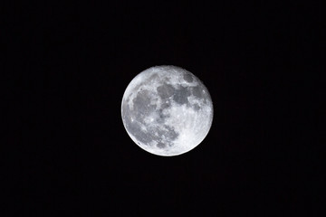 full moon over dark black sky background at night. Lunar perigee super moon coincidence of a full...