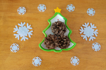 Christmas plate in the shape of a Christmas tree on the background of snowflakes