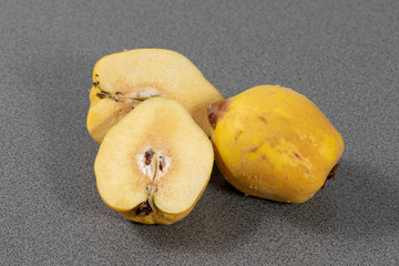 Halved quince beside a quince in the kitchen 