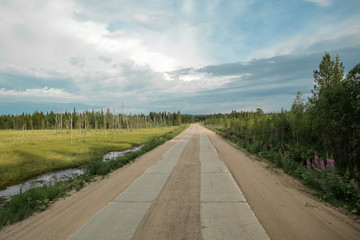 Fototapeta premium The nature of the Russian North. Arkhangelsk region. Clouds over the road