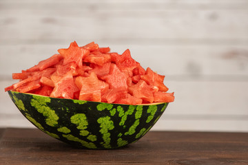 Watermelon slices in the shape of a star in bowl on a dark wooden background