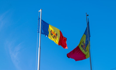 Two moldavian flags flutter in the blue sky