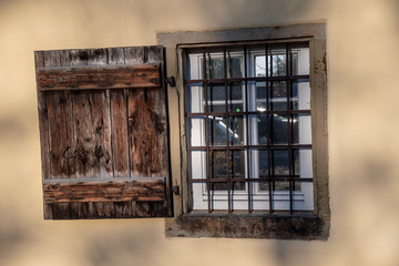 Window with grille and old wooden shutter
