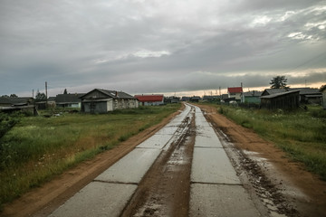 Fototapeta na wymiar The nature of the Russian North. Arkhangelsk region. Clouds over the road in the village. Rain