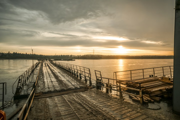 Fototapeta na wymiar Pontoon crossing the river. Sunset