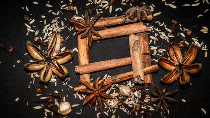 various aromatic spices and herbs on black background. star anise, cloves, cardamom, cinnamon stick