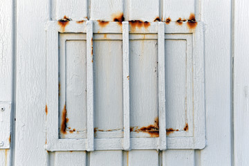 A metal door of a prison with a rusty grid in Mexico-City.