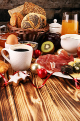 breakfast on table with bread buns, croissants, coffe and juice on christmas day. xmas holiday...