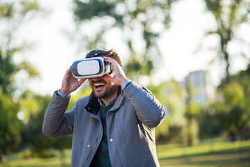 Businessman using vr headset in a park