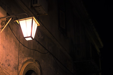 Fototapeta na wymiar night back street wall lantern yellow light from lamp