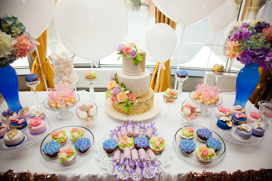luxury wedding catering, table with modern desserts, cupcakes, sweets with fruits. delicious candy bar at expensive wedding reception. space for text. shower. holiday celebration