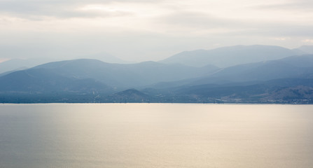 morning mountains silhouettes and calm sea bay horizon landscape panorama in quiet sun rise morning time 