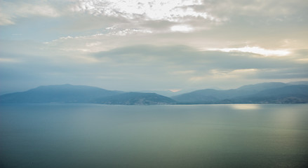 morning mountains silhouettes and calm sea bay horizon landscape panorama in quiet sun rise morning time 