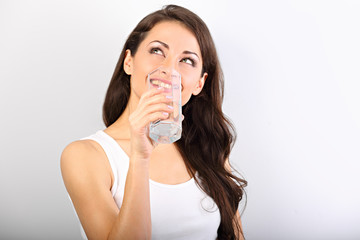 Positive happy smiling woman with healthy skin and long curly hair drinking pure water and looking up on white background. Closeup