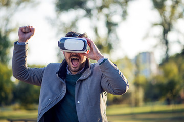 Businessman using vr headset in a park