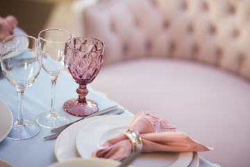 Wedding dinner service. Crystal glasses and porcelain plates served on the dinner table