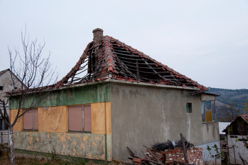 Ruined slate roof hole on top of old stone house