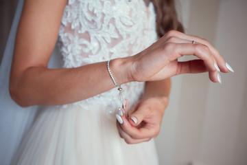 Bride puts on her wrist silver bracelet