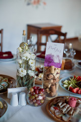 Wedding candy bar service. Delicious macaroons, cookies, pieces of cake and other sweets with chocolate, berries and cream served on the dinner table