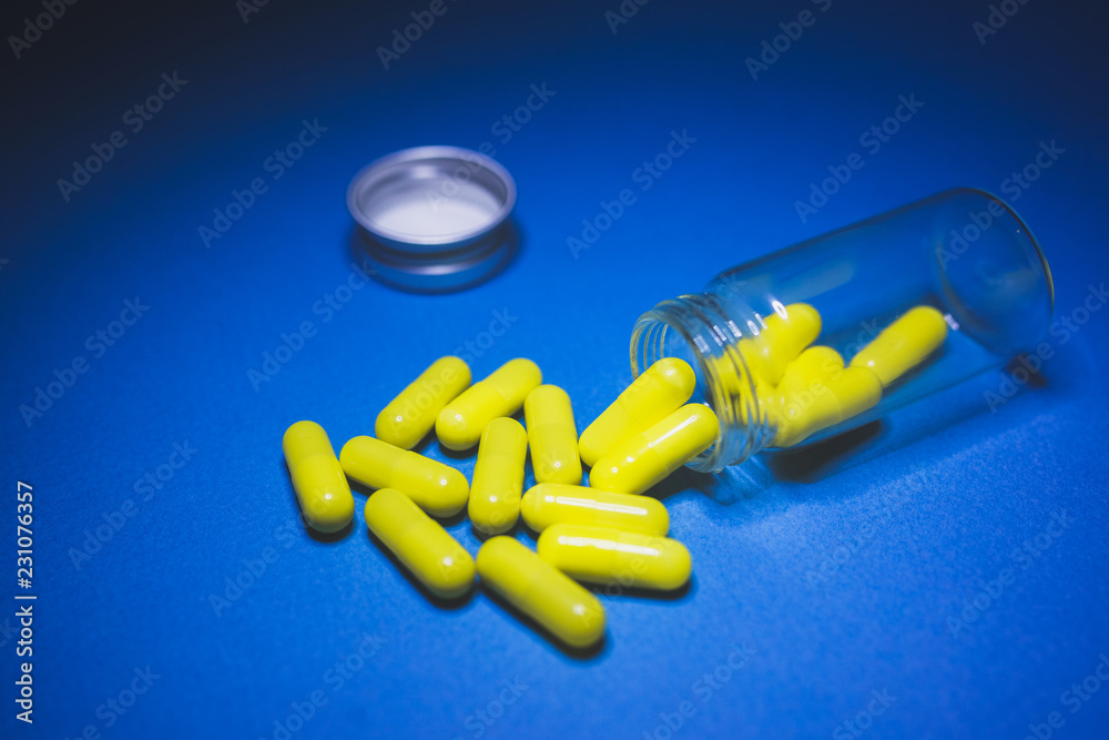 Wall mural tablets and pills on a blue background, a bottle for tablets