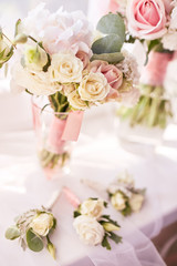 Wedding decor. Bright pink rose bouquet for a bride and bridesmaids stand before a window