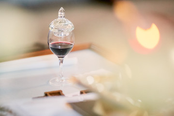 Glass with wine stands on the table in church