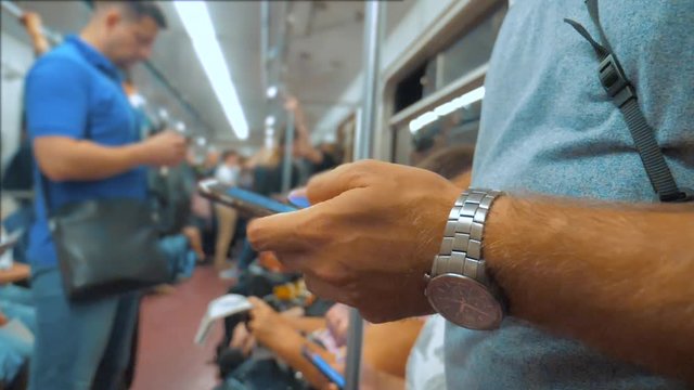Casual man reading from mobile phone smartphone screen while looks the navigator traveling on metro lifestyle in the subway. slow motion video. Wireless internet on public transport concept. man in