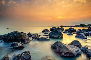 A long exposure picture Beautiful Scenery cloudy Sunset With Stone and wave As Foreground © hamdie
