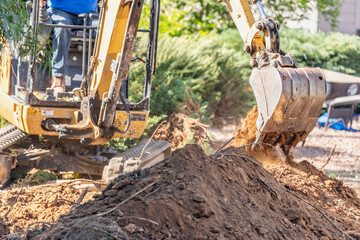 Fototapeta premium Working Excavator Tractor Digging A Trench At Construction Site