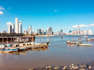 Panama City Cityscape and skyline behind old fisher boats at fish market / harbor  -