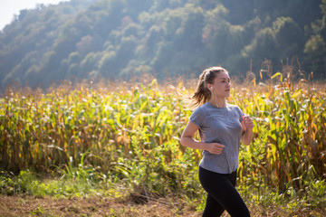 woman jogging along a country road