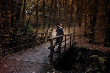 mujer en el puente en medio de la naturaleza